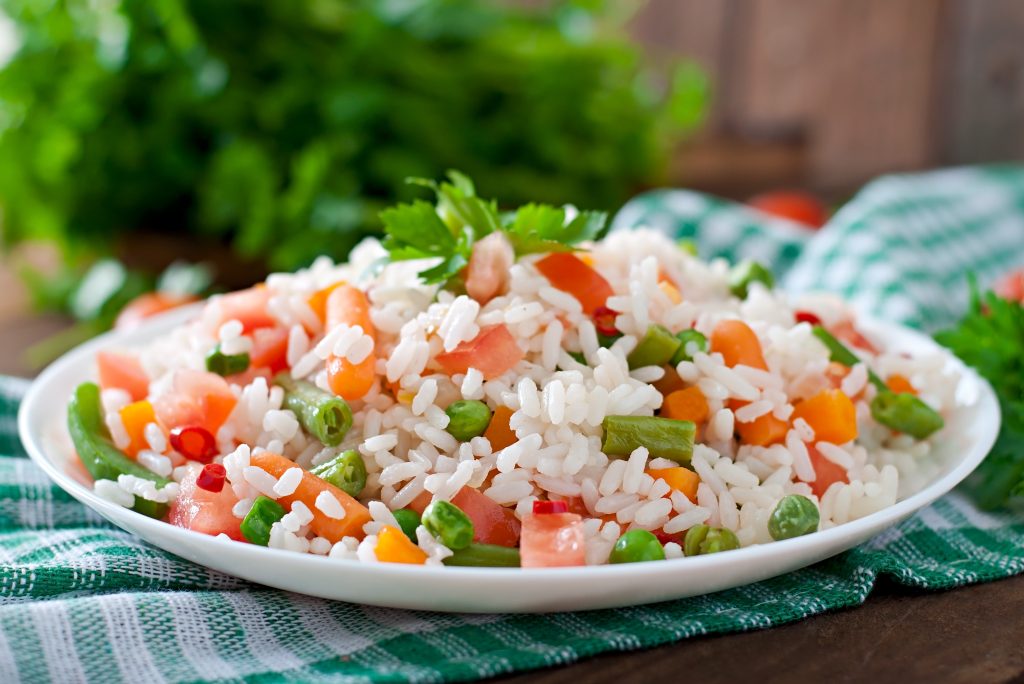 306093_appetizing-healthy-rice-with-vegetables-in-white-plate-on-a-wooden-table